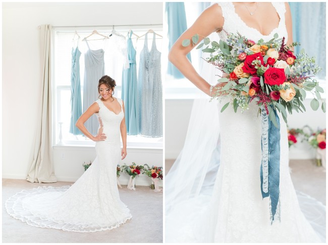 Bride in Olvi’s gown in front of window holding rustic organic bouquet with blue ribbons