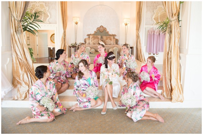 Bride and bridesmaids in coral robes at Mallard Island Yacht Club