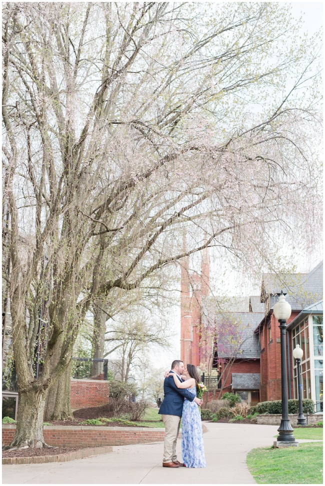engaged couple kissing under the cherry blossom tree at Franklin and Marshall College