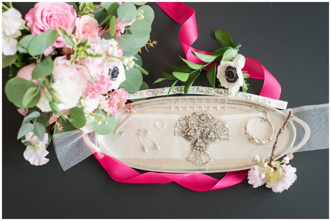 Bridal jewelry on decorative tray with bouquet