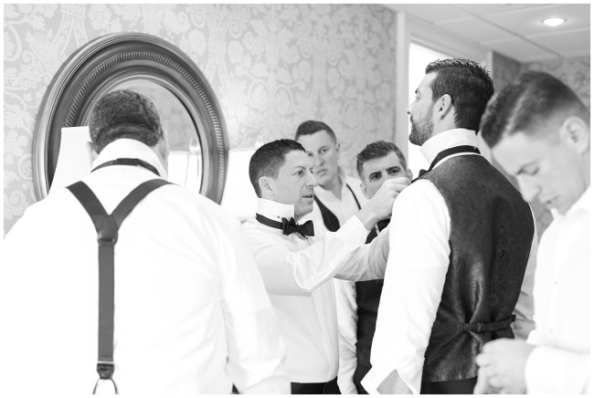 Black and white photo of groomsmen getting ready at Mallard Island Yacht Club