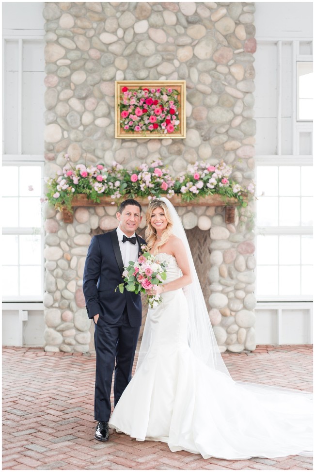 Bride and Groom in front of stone fireplace at Mallard Island Yacht Club