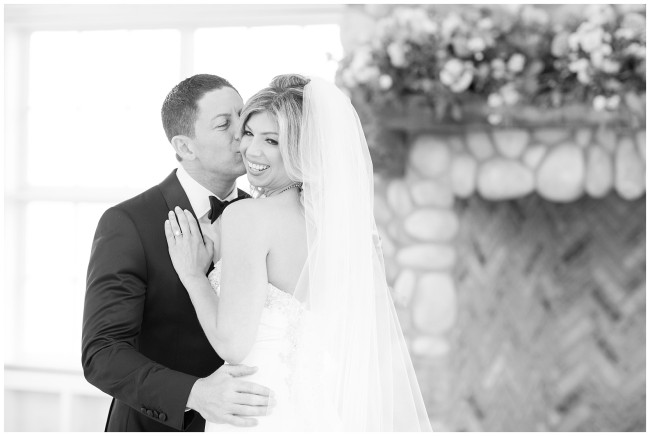 Black and white picture of groom kissing brides cheek