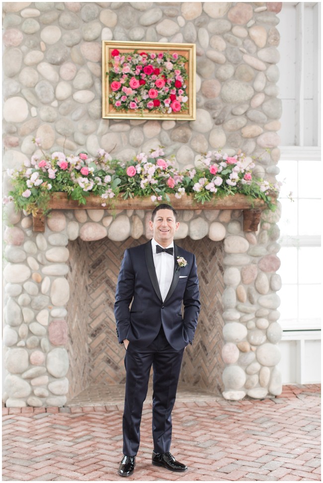 Handsome groom in front of stone fireplace at Mallard Island Yacht Club
