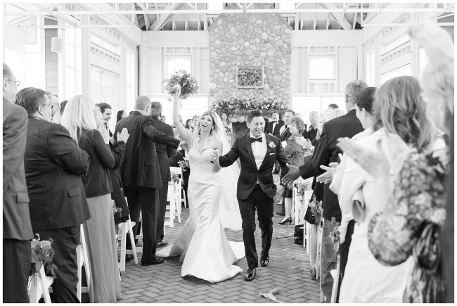 black and white photo of bride and groom walking down the aisle at Mallard Island Yacht Club