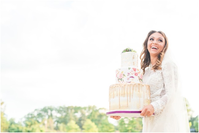 bride holding a three tiered wedding cake