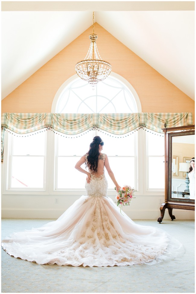 Bride in window in Stephen Yearick bridal gown at Mallard Island Yacht Club