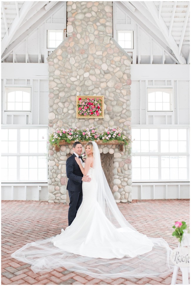Couple in front of stone fireplace in boathouse chapel at Mallard Island Yacht Club