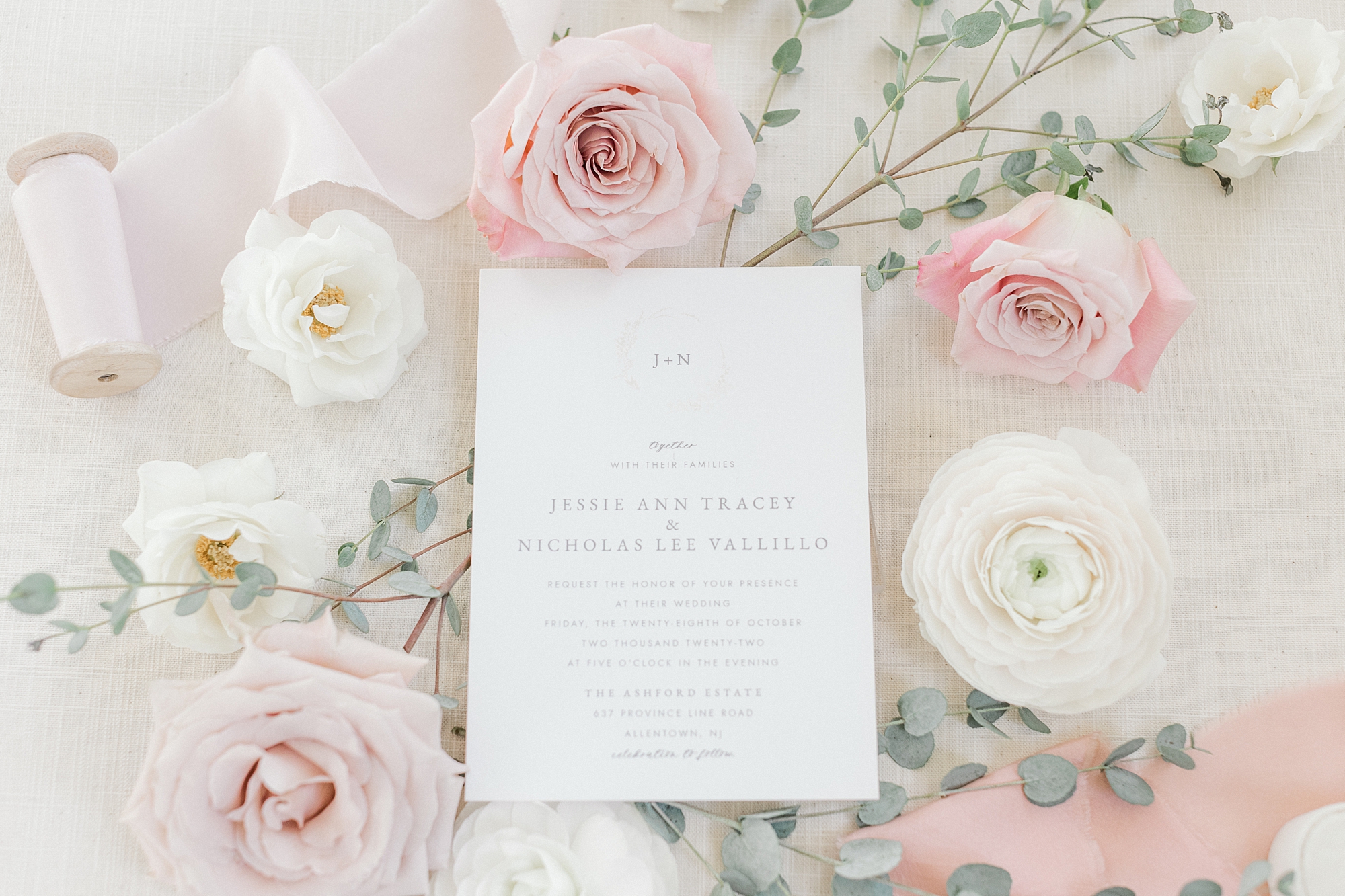 classic stationery for Ashford Estate wedding sits surrounded by pastel pink roses and white flowers