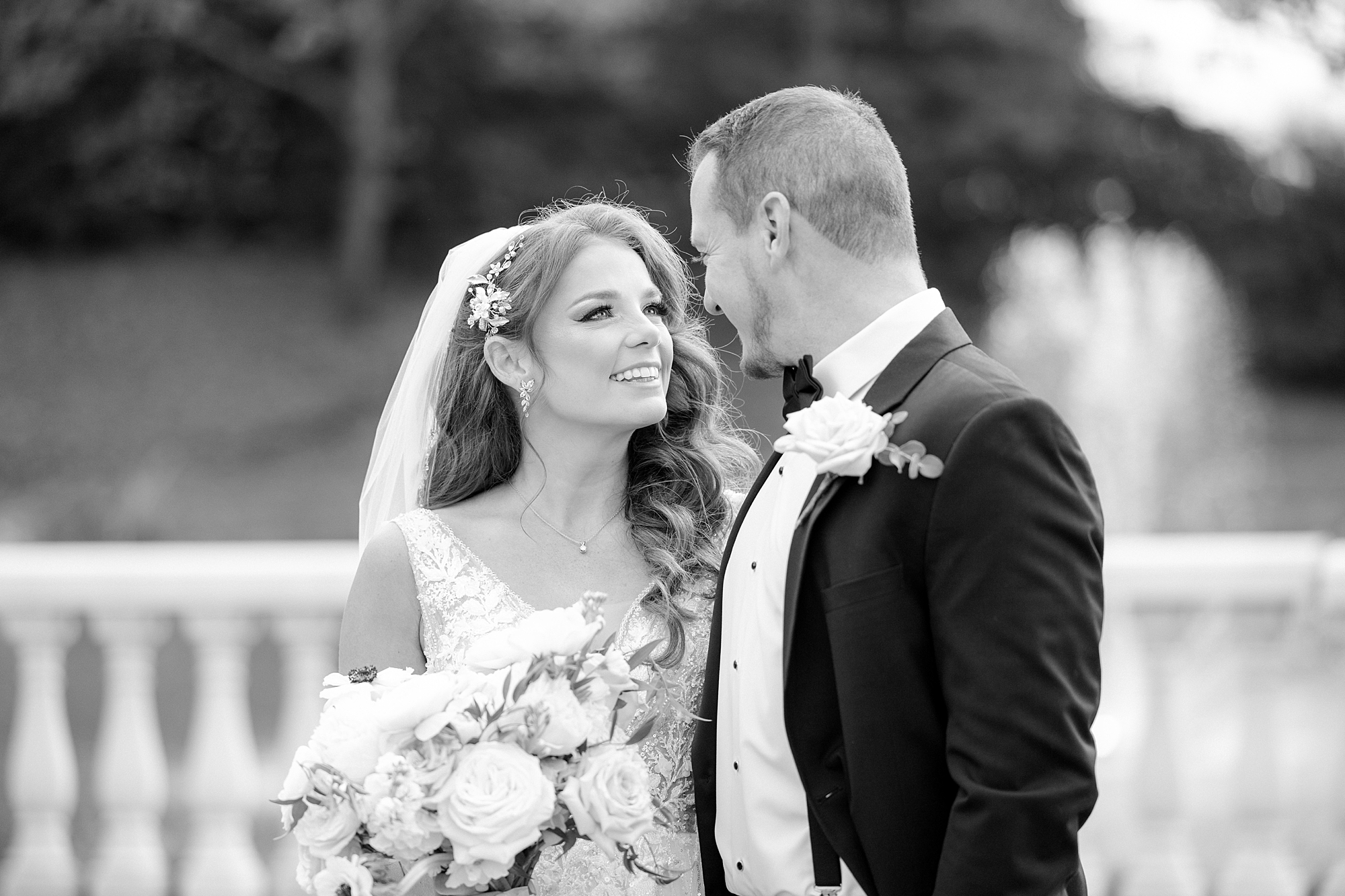 black and white portrait of bride smiling up at groom near water at the Ashford Estate