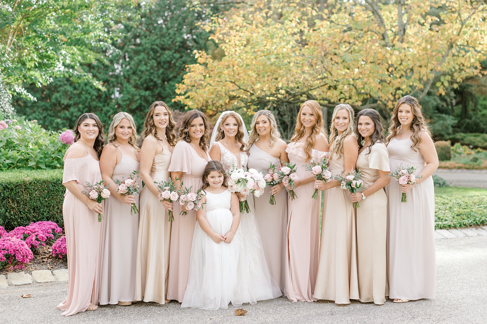 bride poses with bridesmaids in Champagne gowns outside the Ashford Estate