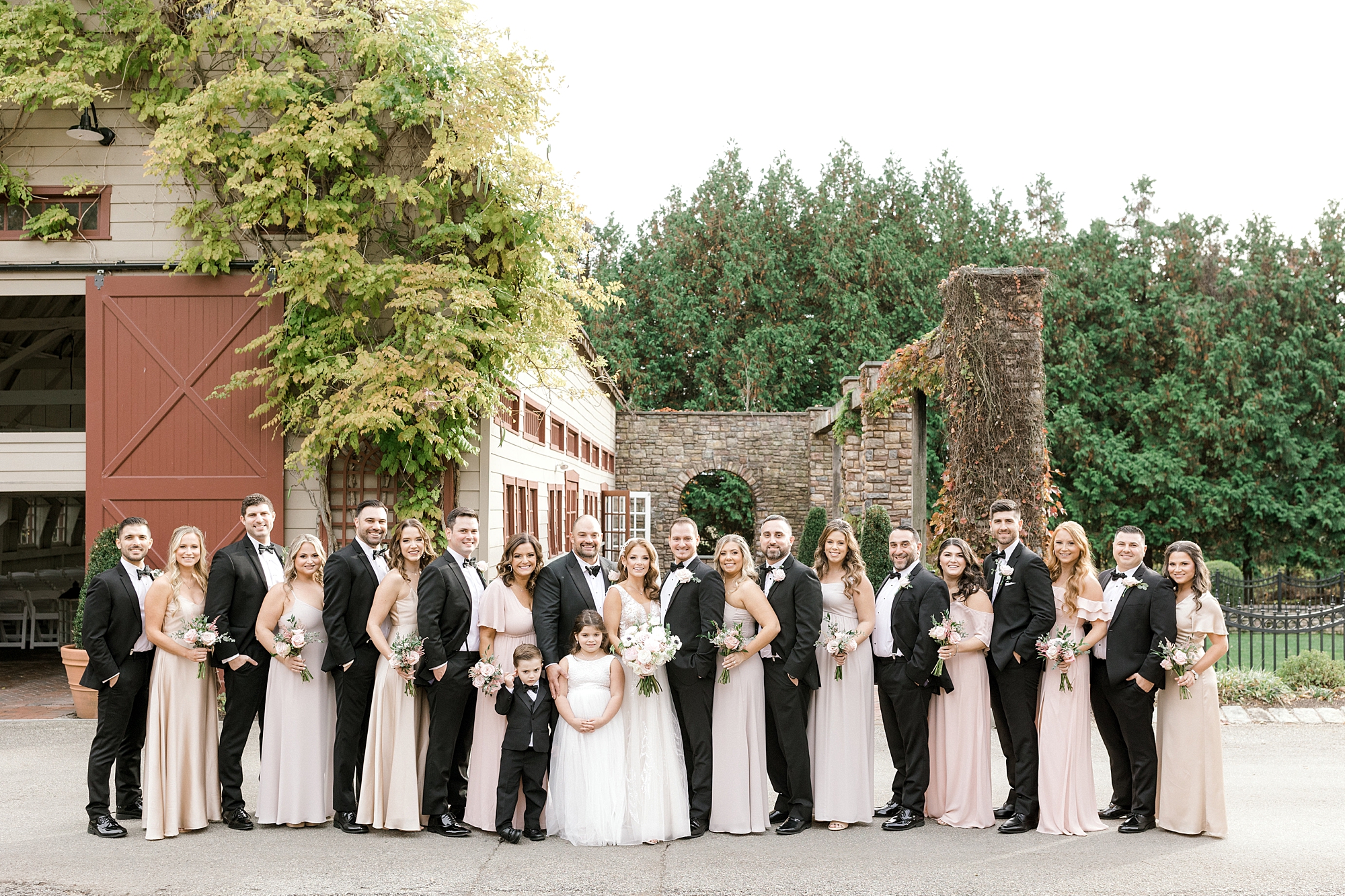 bride and groom pose with wedding party in black tuxes and champagne gowns at the Ashford Estate