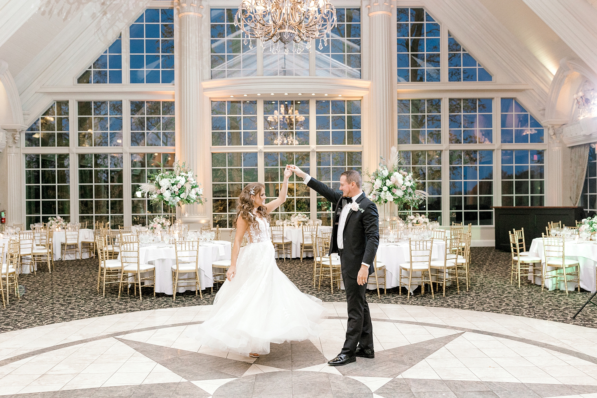 groom twirls bride inside ballroom at the Ashford Estate