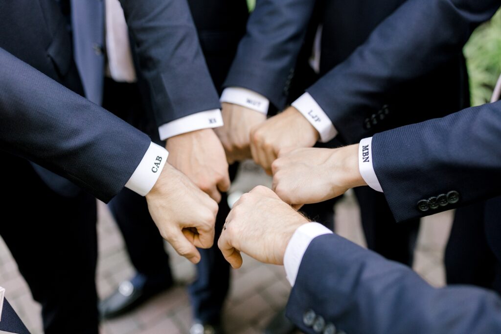 groomsmen show off custom embroidery on suit shits 