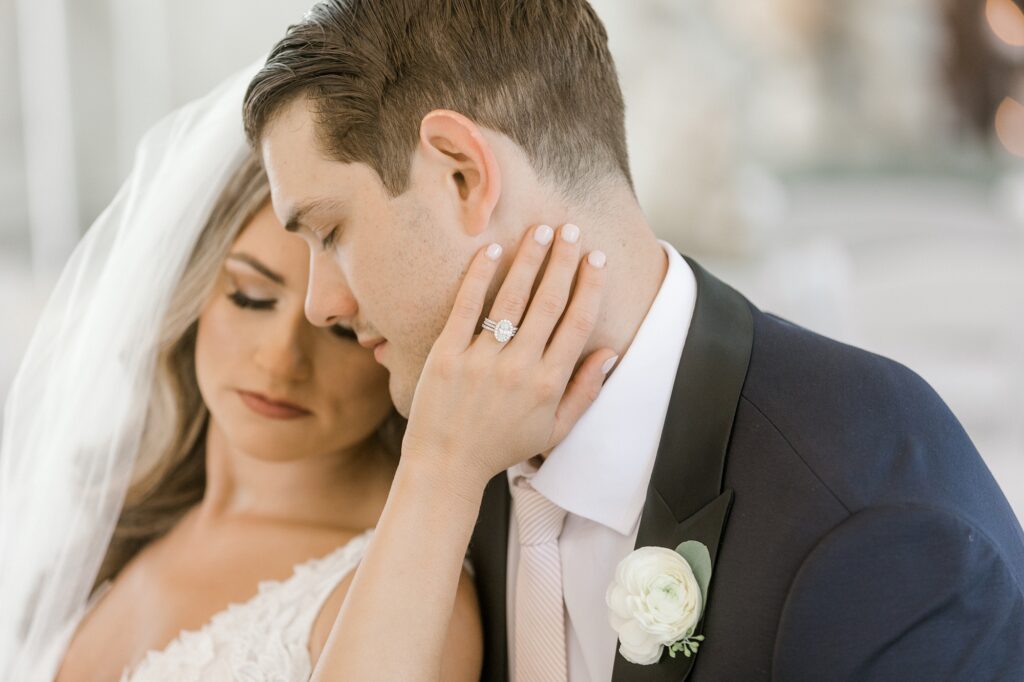 bride holds groom's chin during portraits inside chapel at Bonnet Island Estate