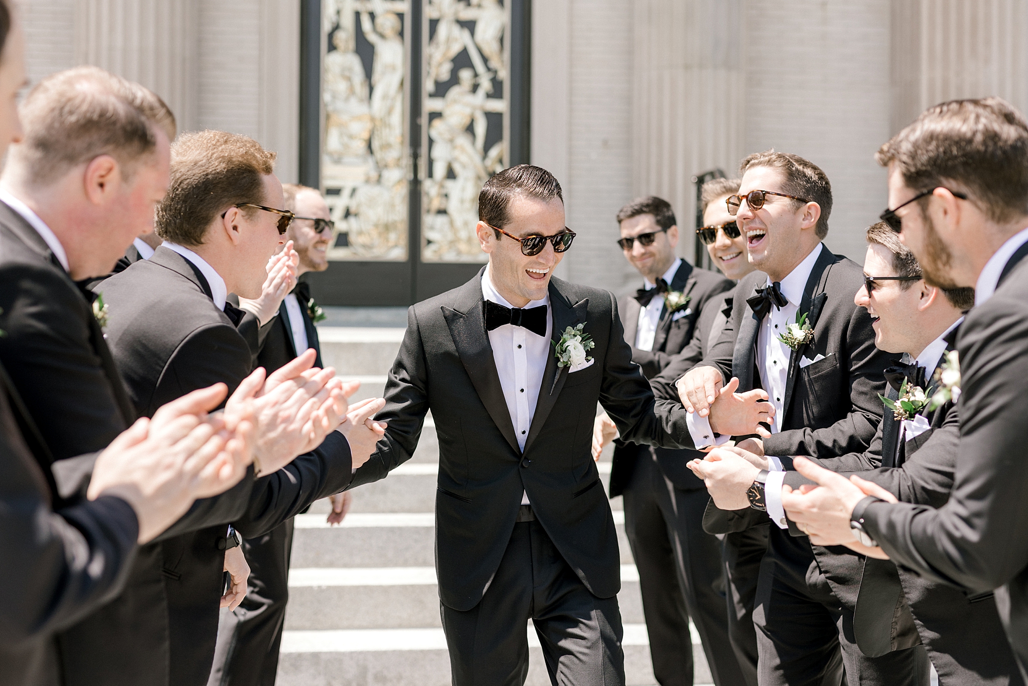 groom runs through groomsmen giving high fives