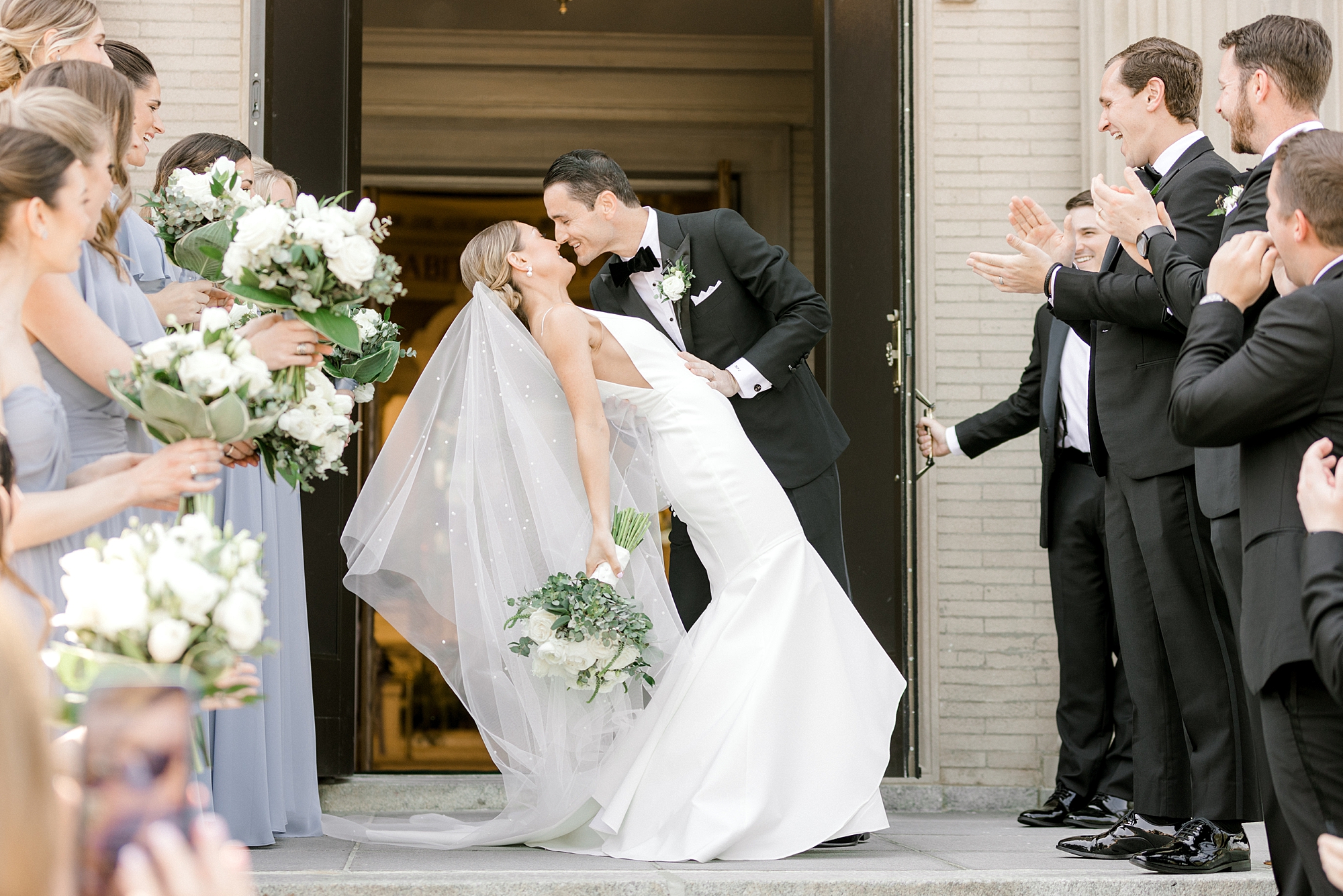 groom dips bride kissing her outside ceremony in New Jersey