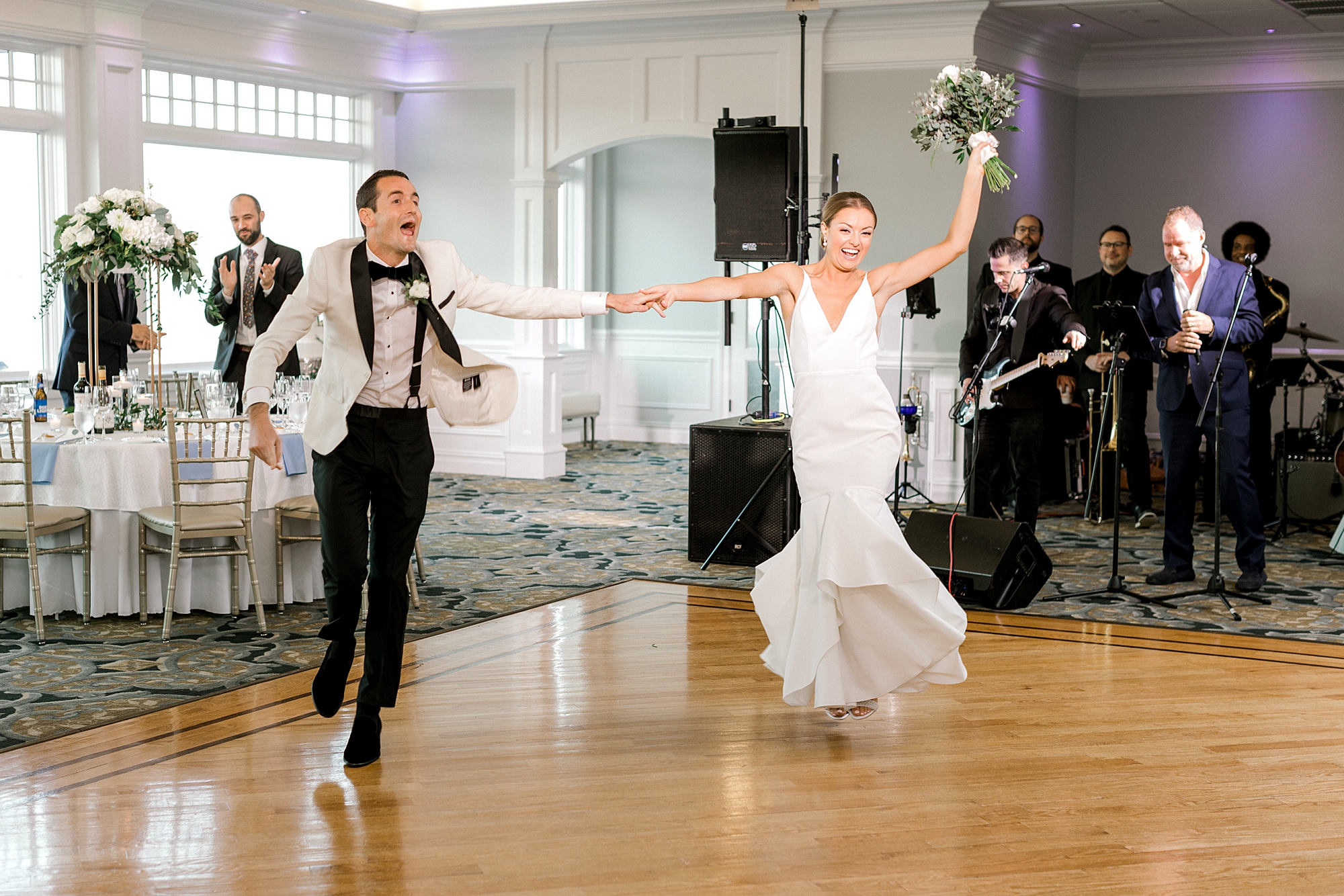 bride and groom cheer walking onto dance floor at Crystal Point Yacht Club