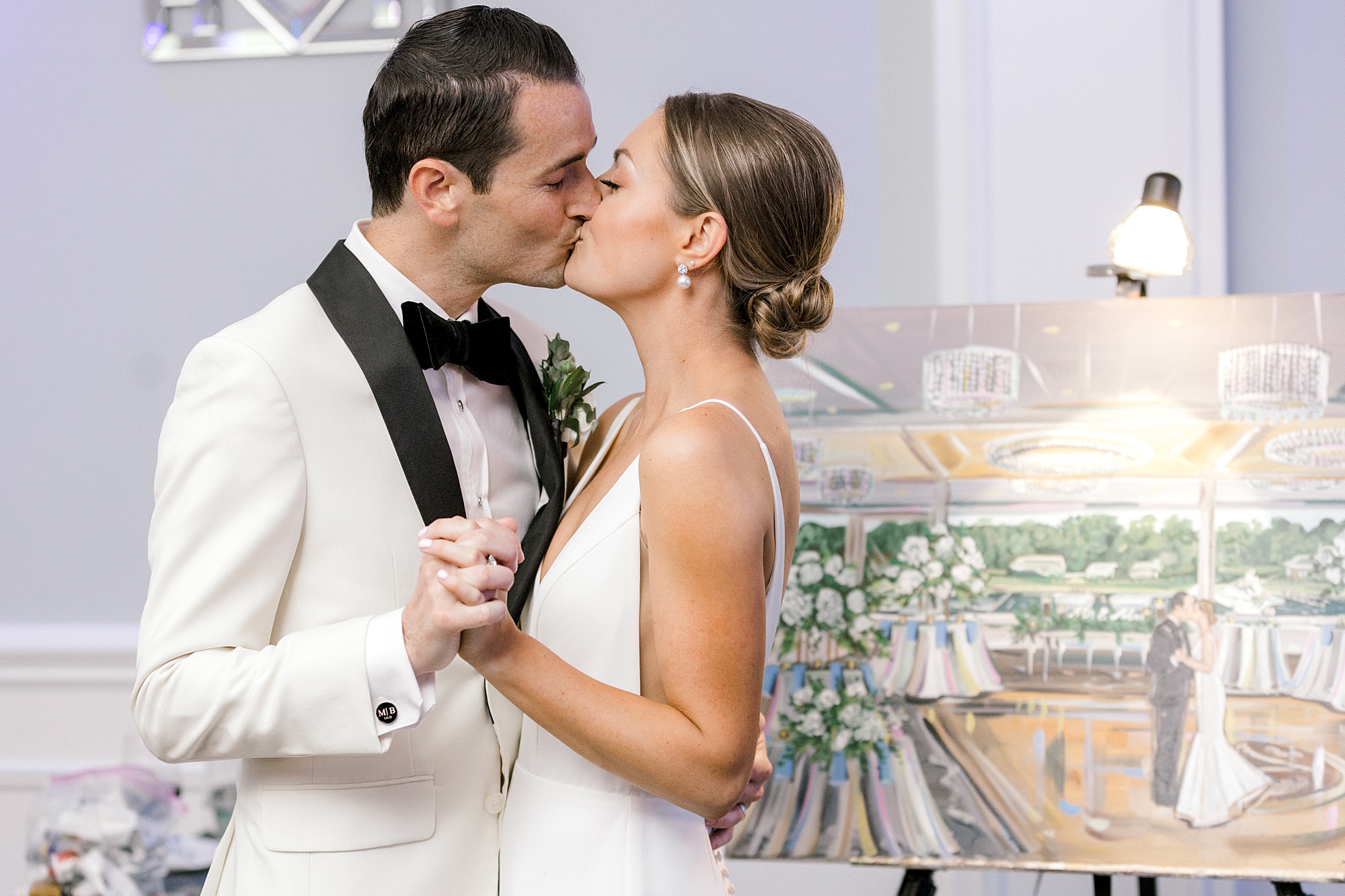newlyweds kiss during wedding reception by painting