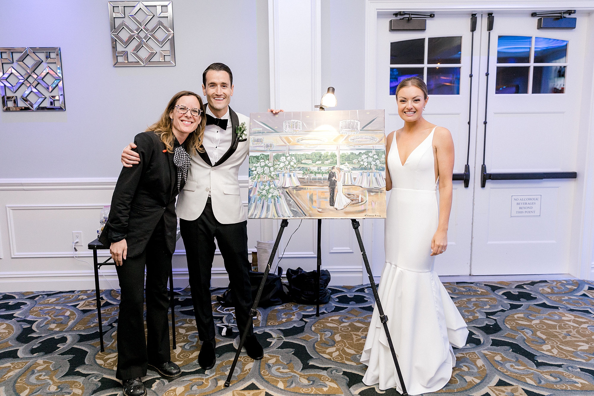 bride and groom pose with painter from wedding reception at Crystal Point Yacht Club
