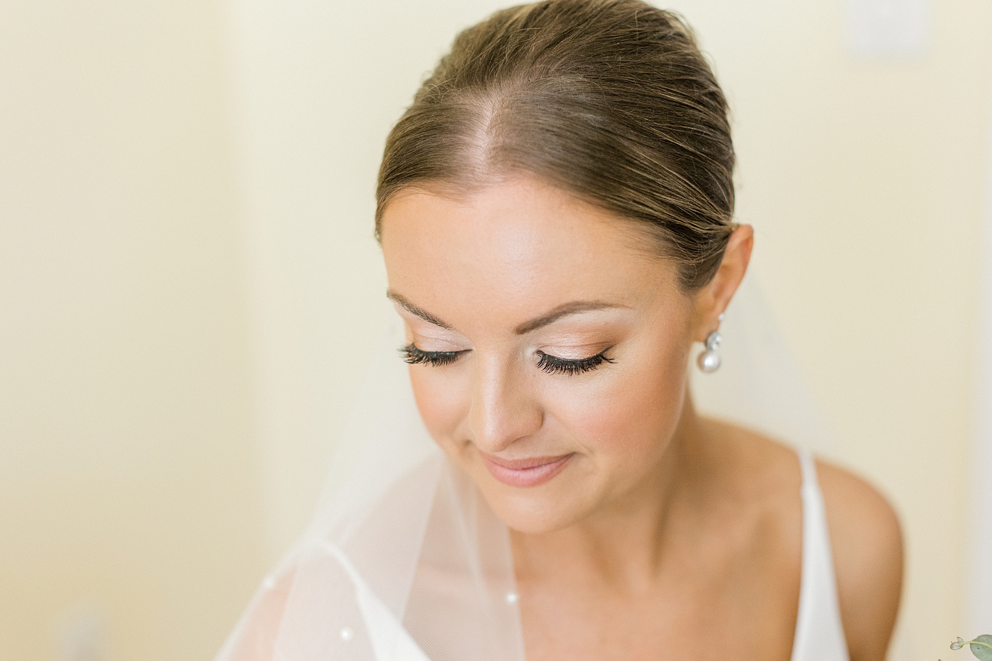 bride looks down over shoulder with veil around her