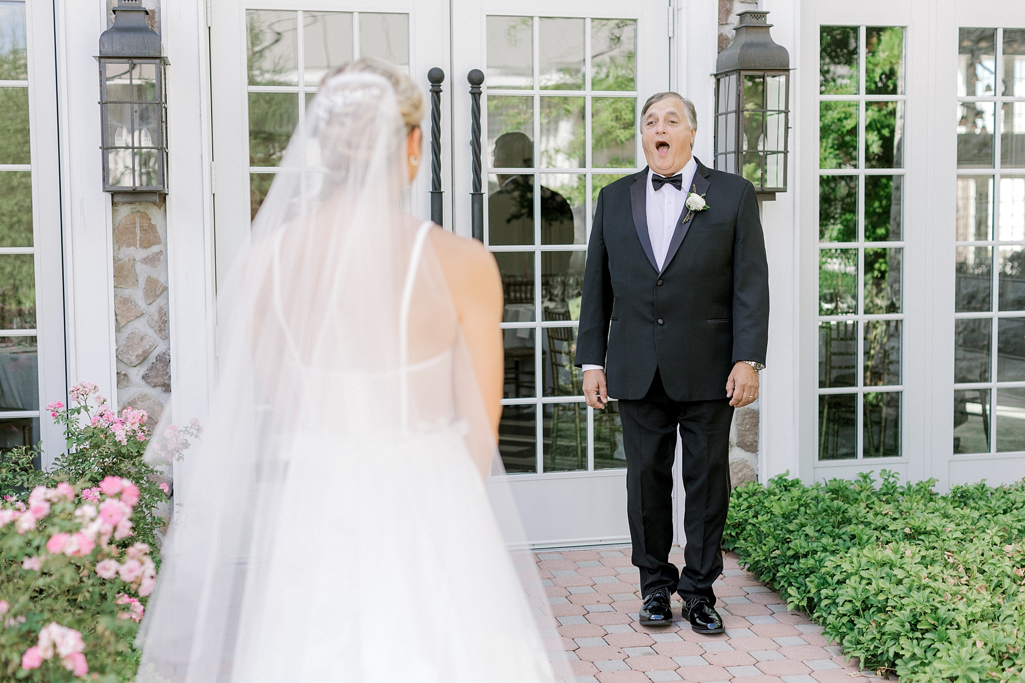 father acts surprised during first look with bride outside of Ryland Inn