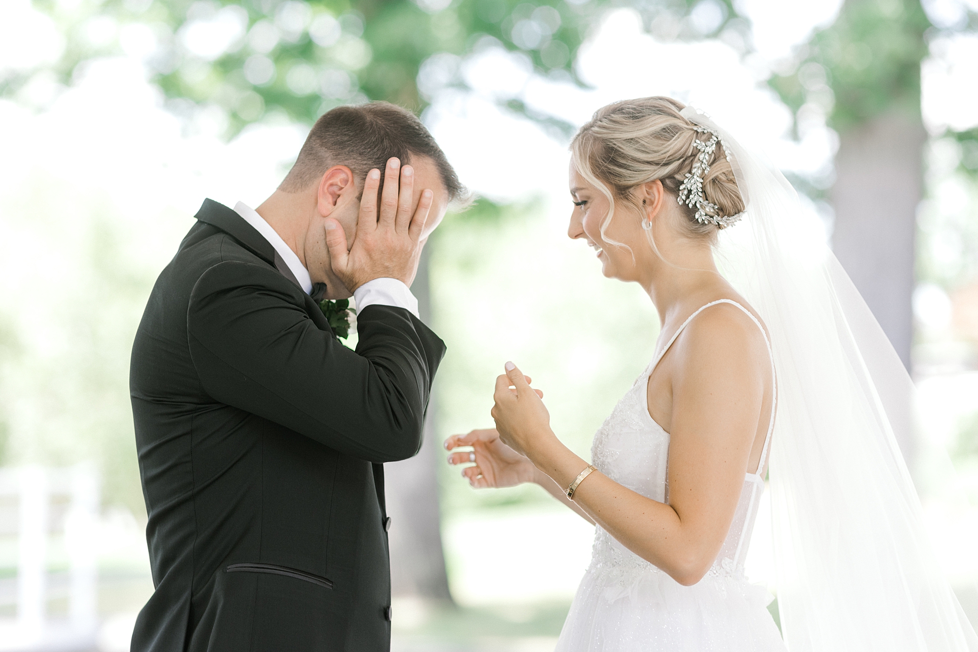 groom wipes away tears on face during first look with bride