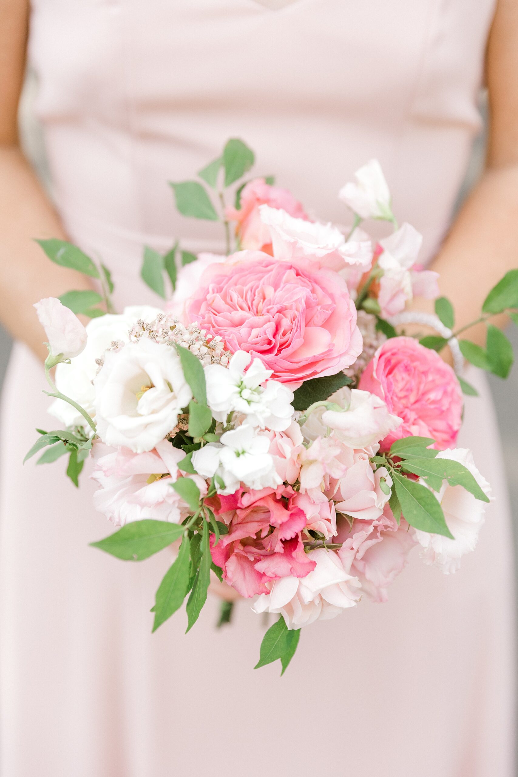 bridesmaid holds bouquet of pink peonies and white flowers