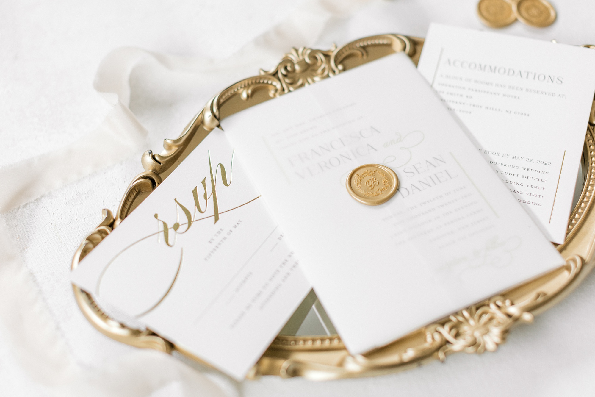 white and gold invitations sit on gold tray