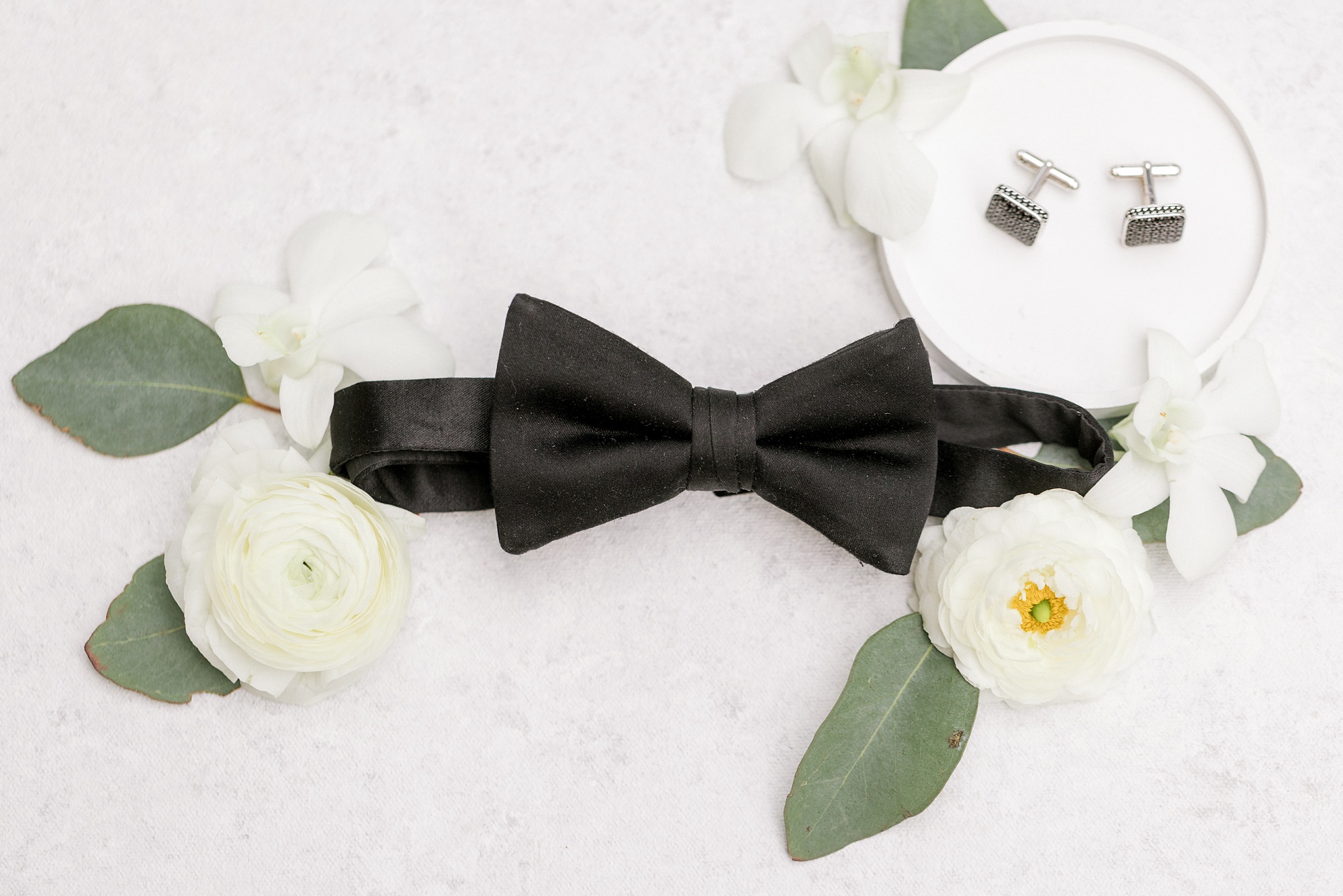 groom's black bow tie and white flowers for The Refinery at Perona Farms wedding
