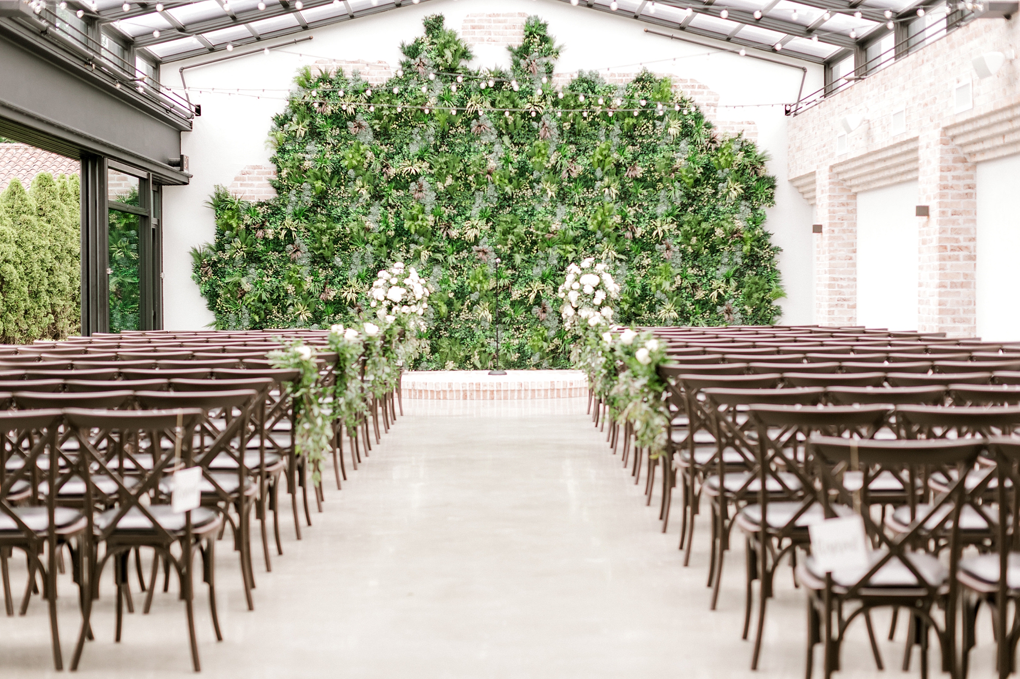 ceremony site in front of greenery wall at The Refinery at Perona Farms