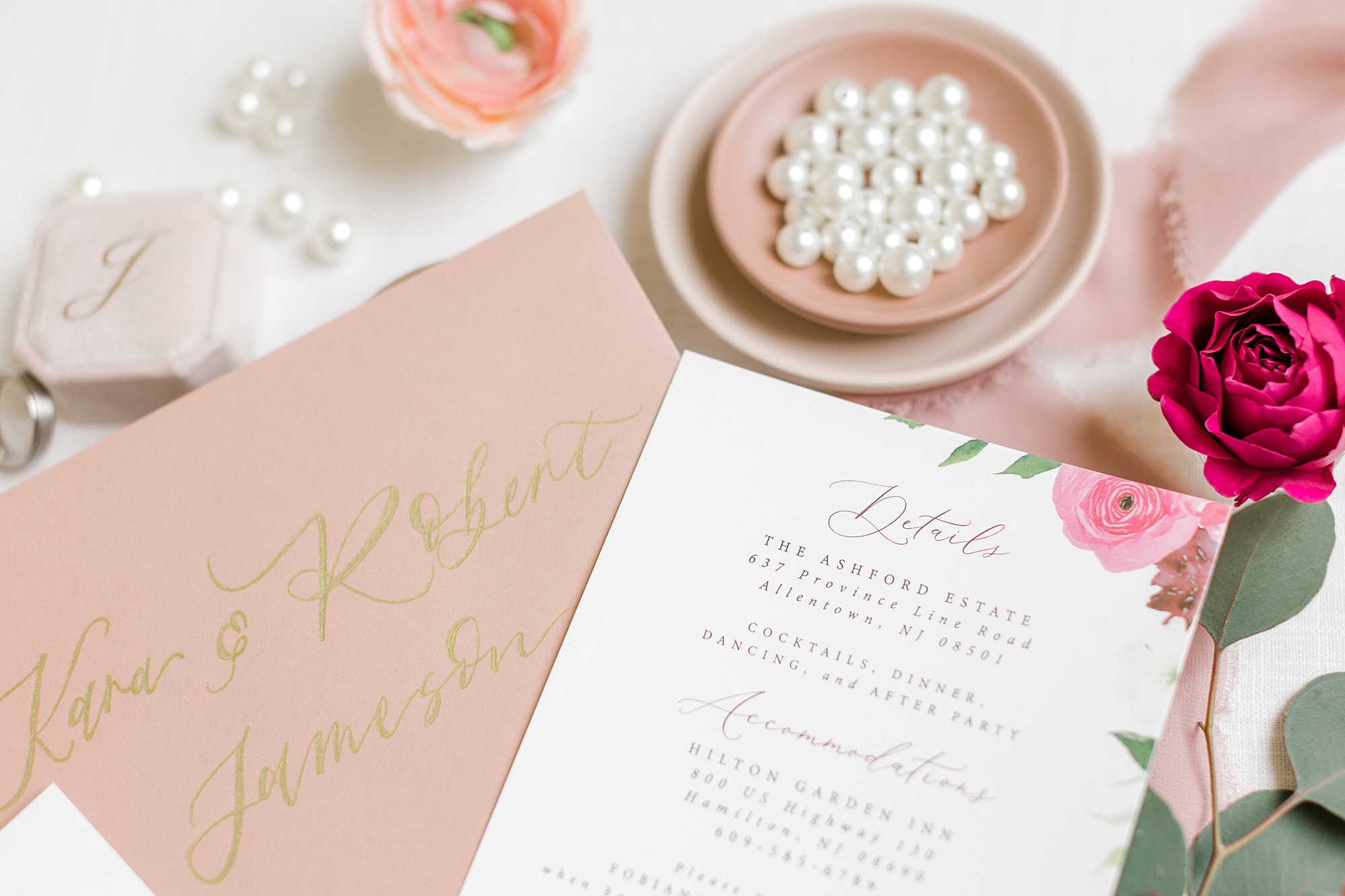 pink and gold invitation next to bowl of pearls