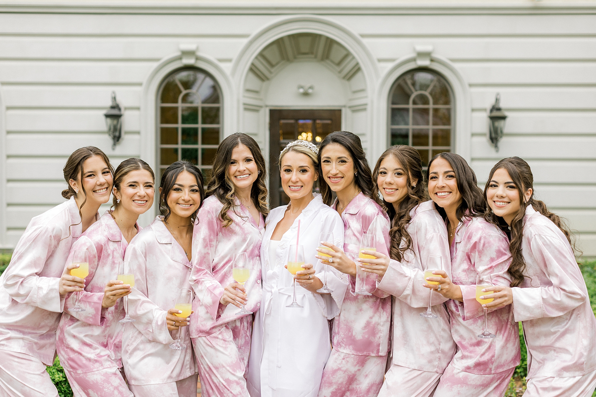 bride poses with bridesmaids in matching pink floral pajamas