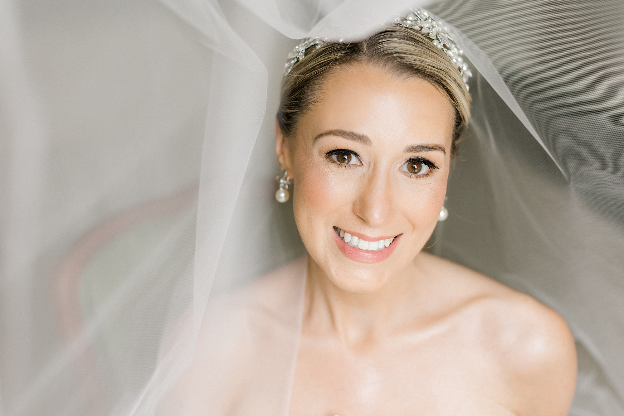 bride smiles under veil with headband