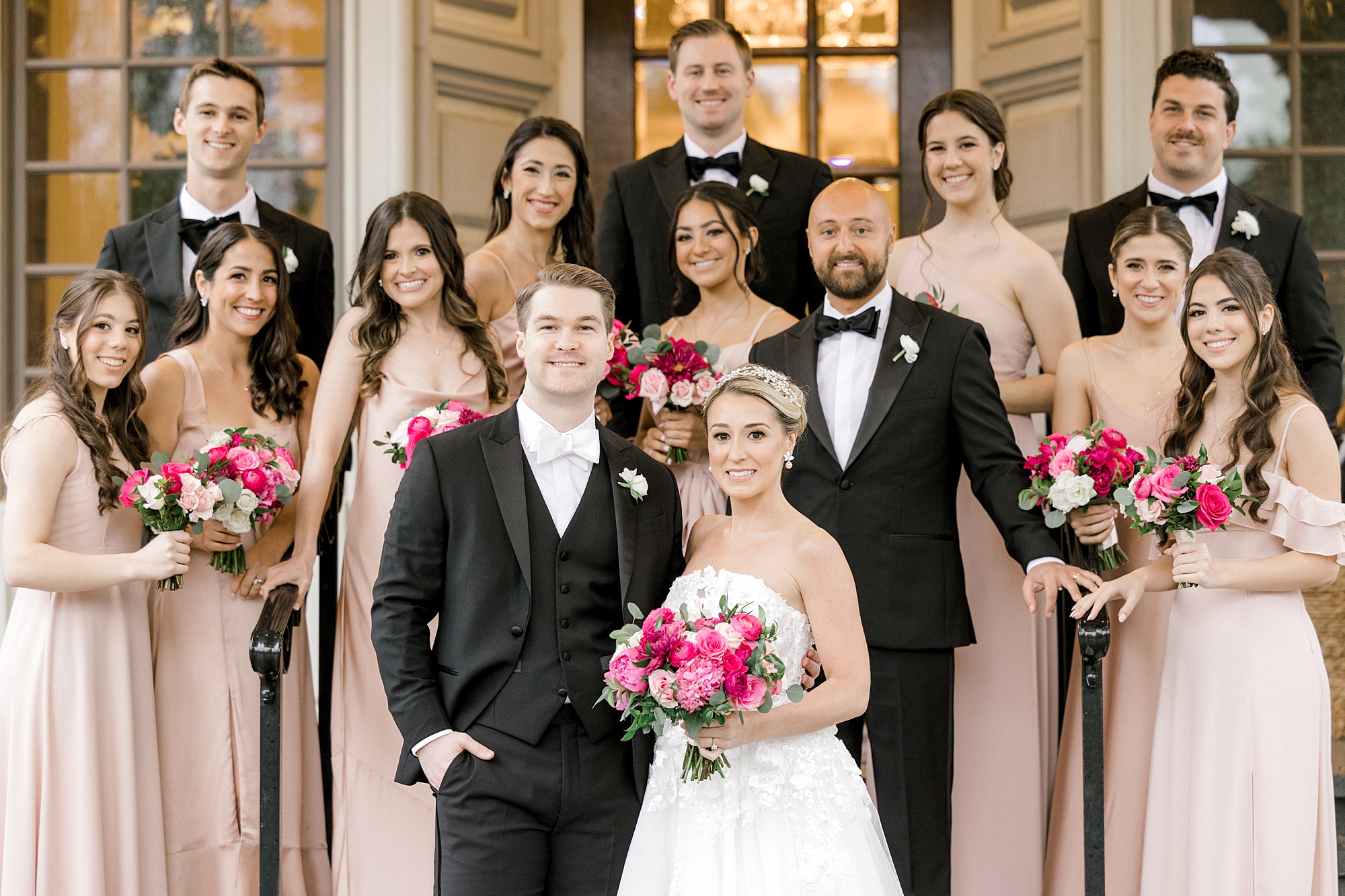 newlyweds stand surrounded by wedding party on steps of The Ashford Estate