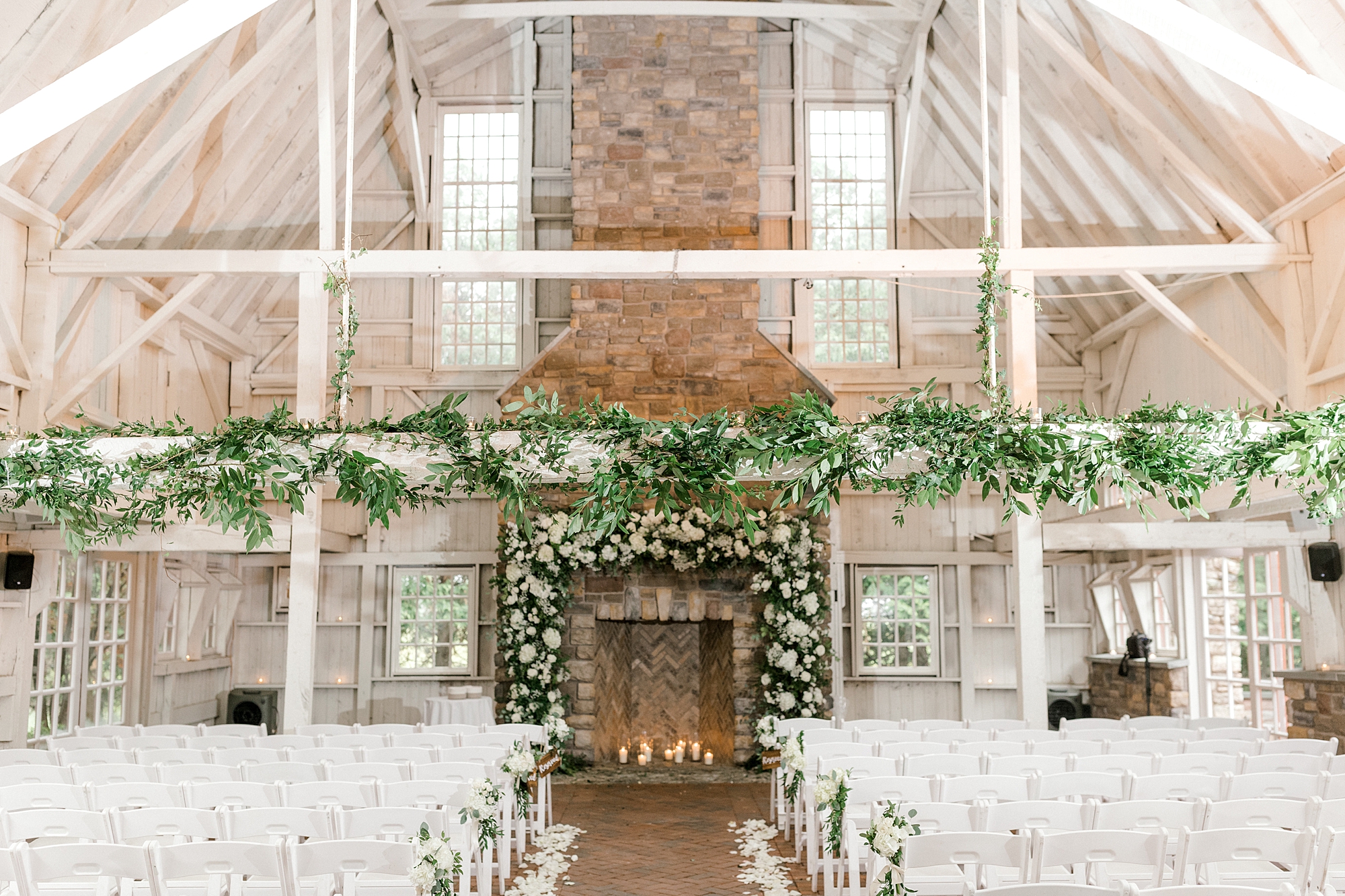 wedding ceremony inside The Ashford Estate with white and green garlands on fireplace