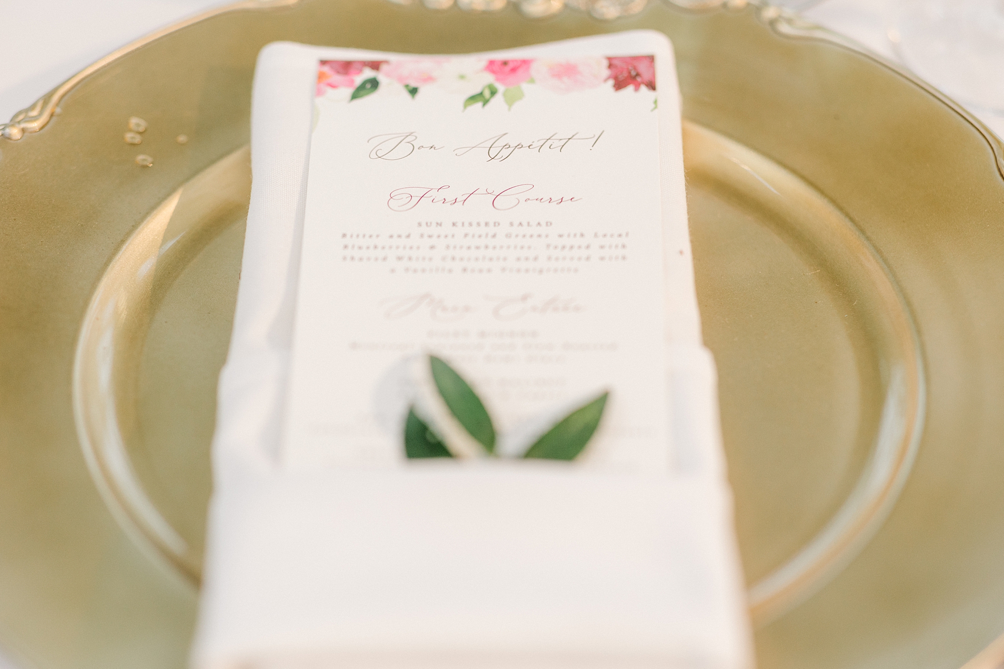 menu card with pink watercolor florals along top on gold charger