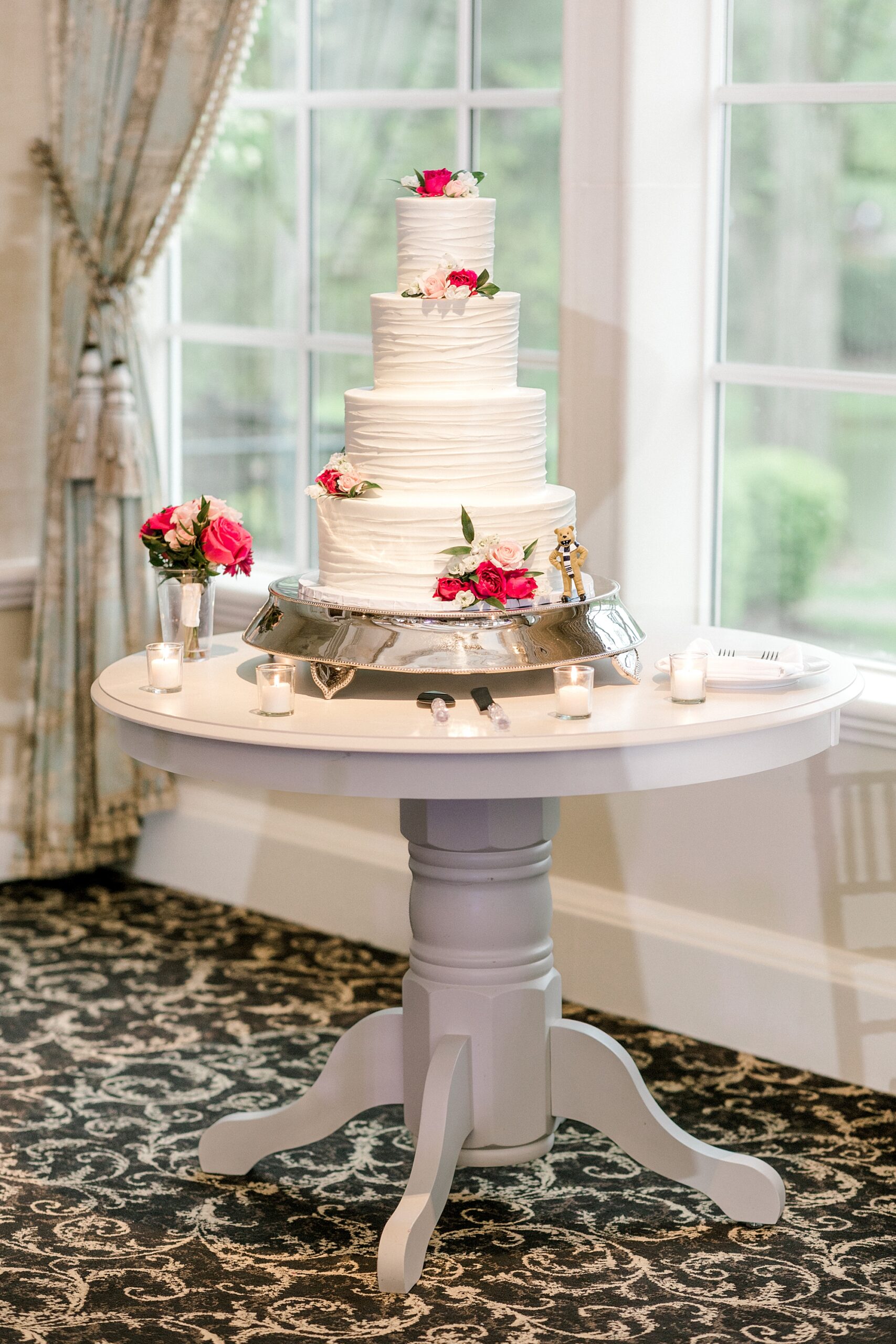 tiered wedding cake with pink rose accents