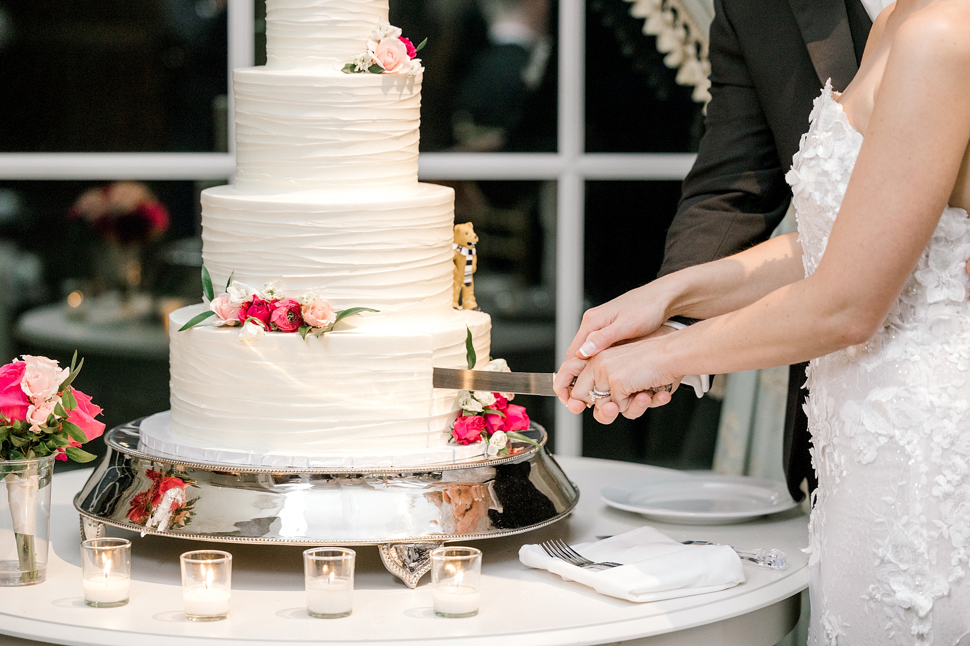 bride and groom hold hands cutting cake during Allentown NJ wedding reception