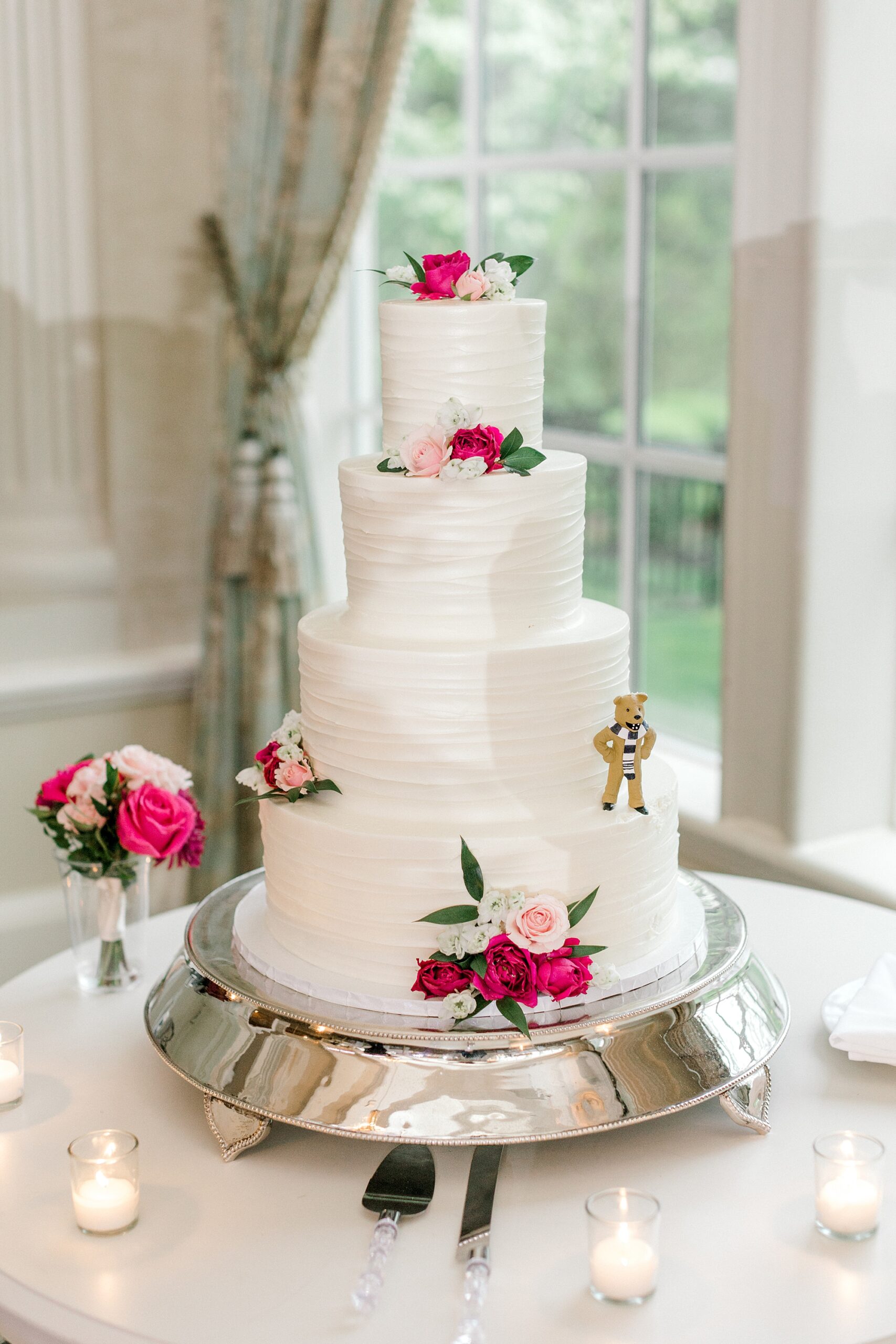 tiered wedding cake with rose accents and figurine