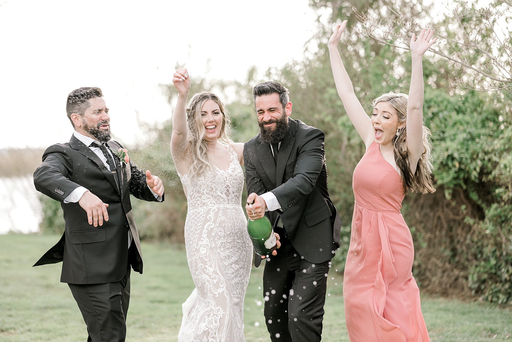 groom pops champagne with wedding party at The Townsend Property
