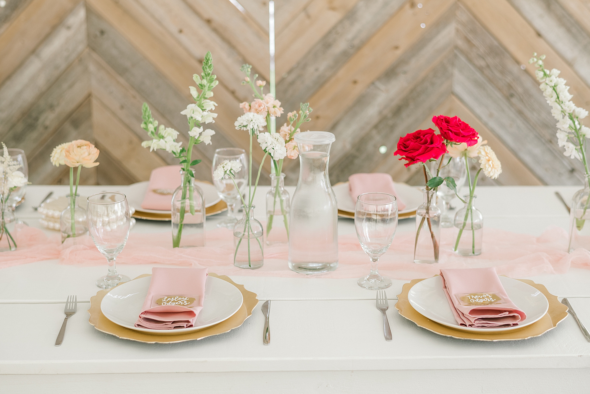 wedding reception table scape with pink wildflower centerpieces and gold and pink place settings