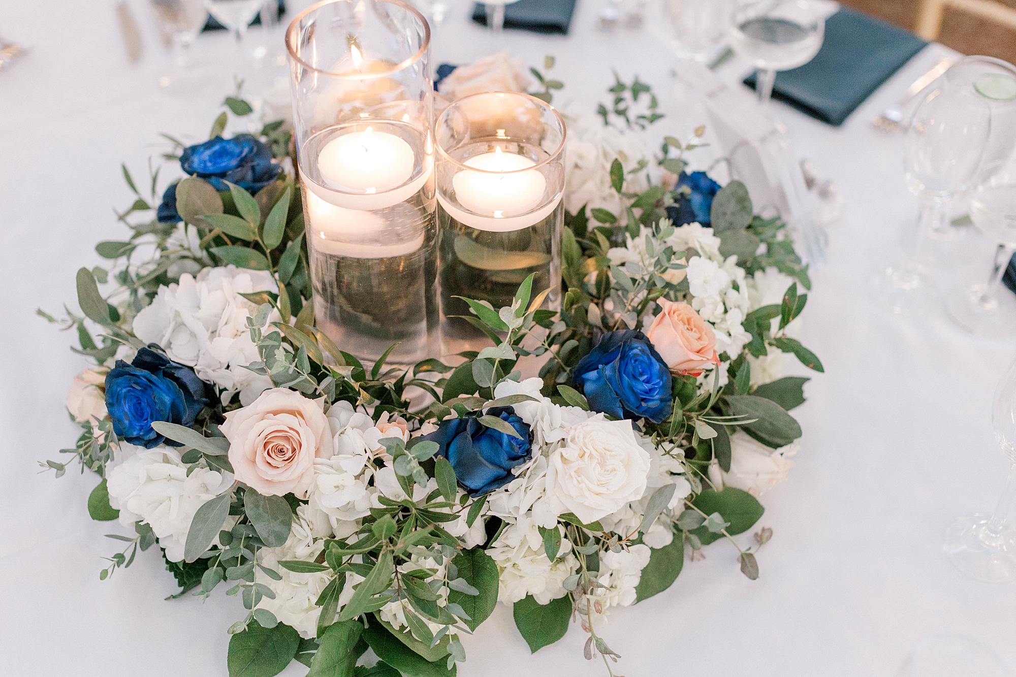 wedding reception centerpieces with white and blue flowers and floating candles
