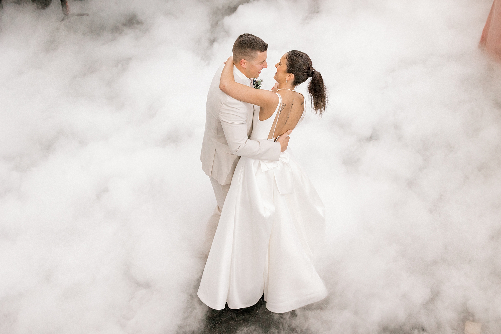 newlyweds dance during first dance with fog around them
