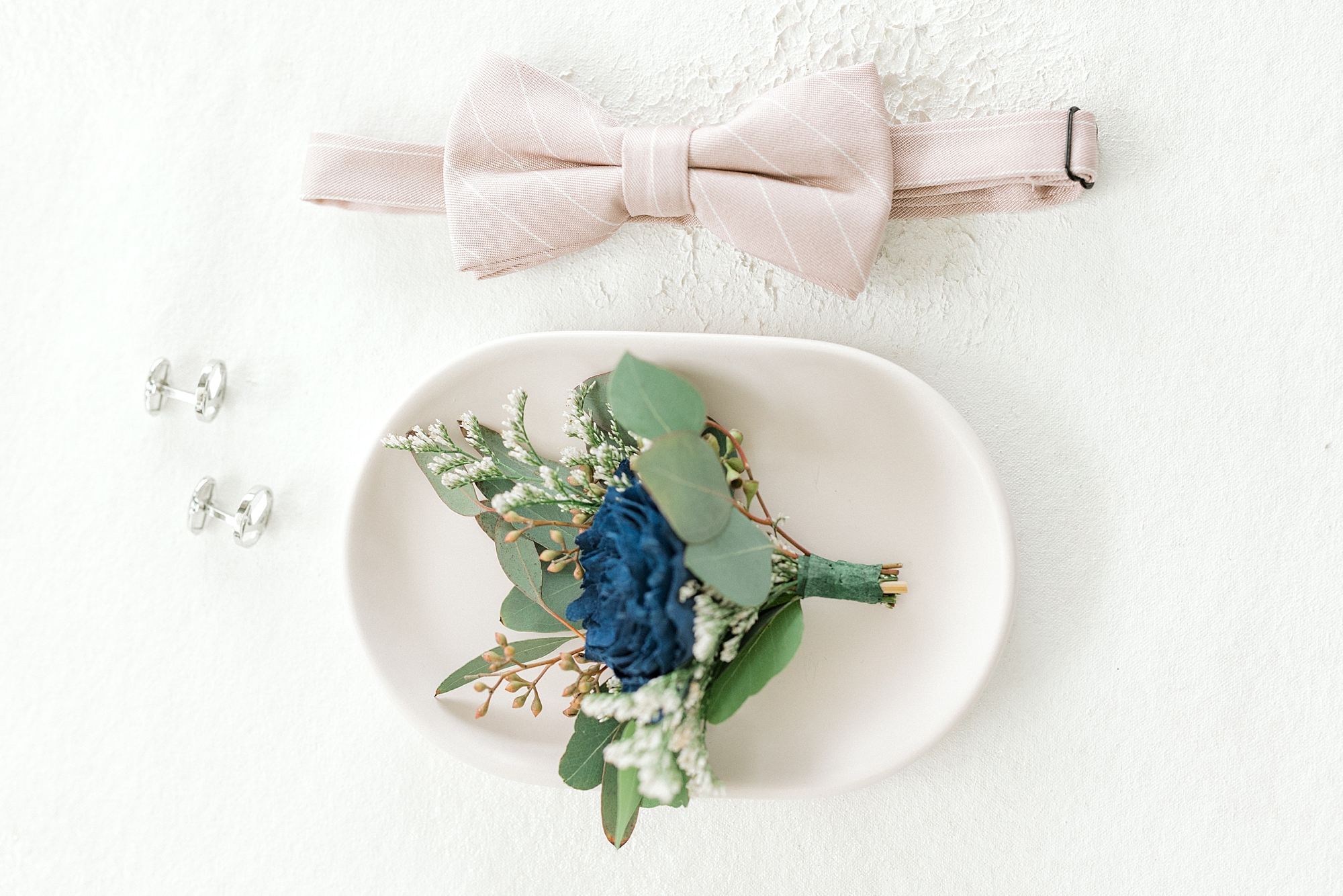 groom's pink bowtie and boutonnière with blue flowers