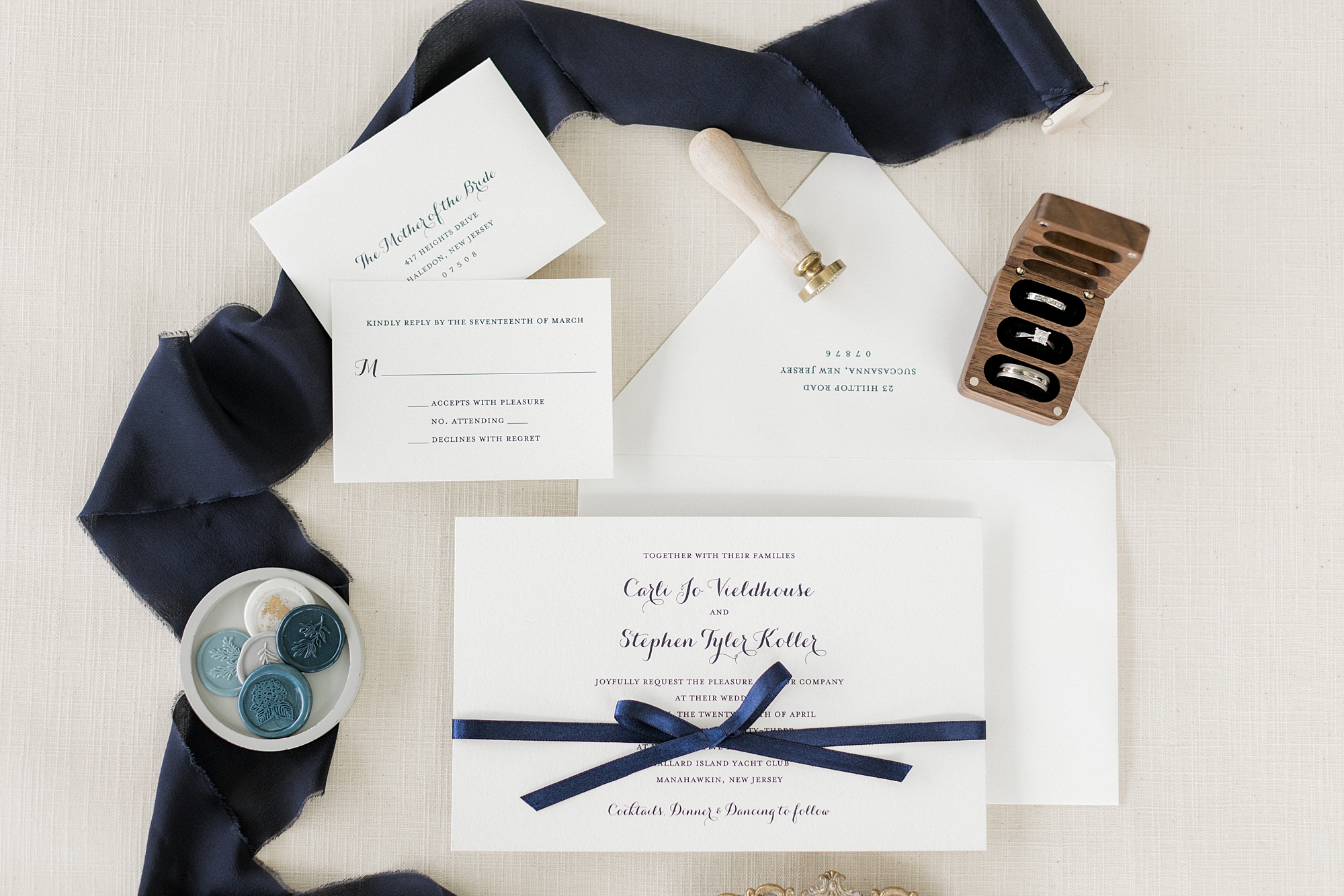 invitation suite with navy blue ribbon and rings around it