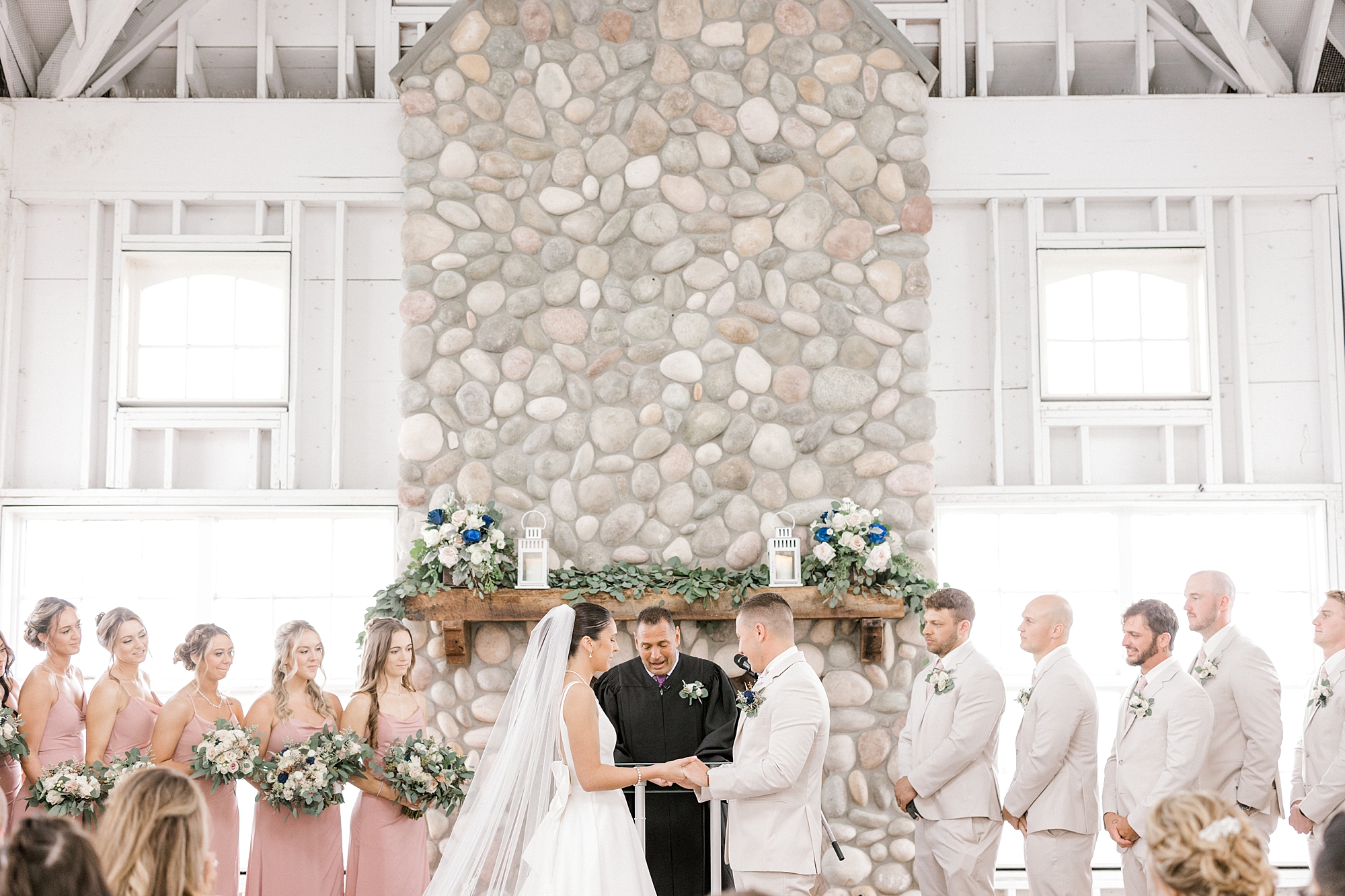 wedding ceremony in front of stone fireplace at Mallard Island Yacht Club