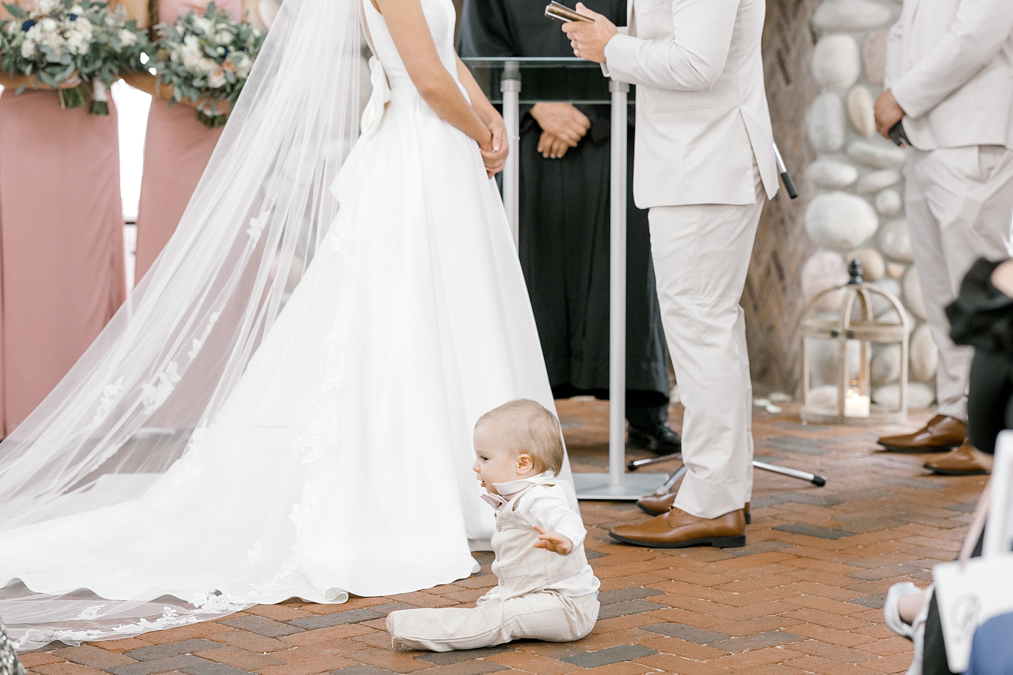 ring bearer sits in front of bride during wedding ceremony