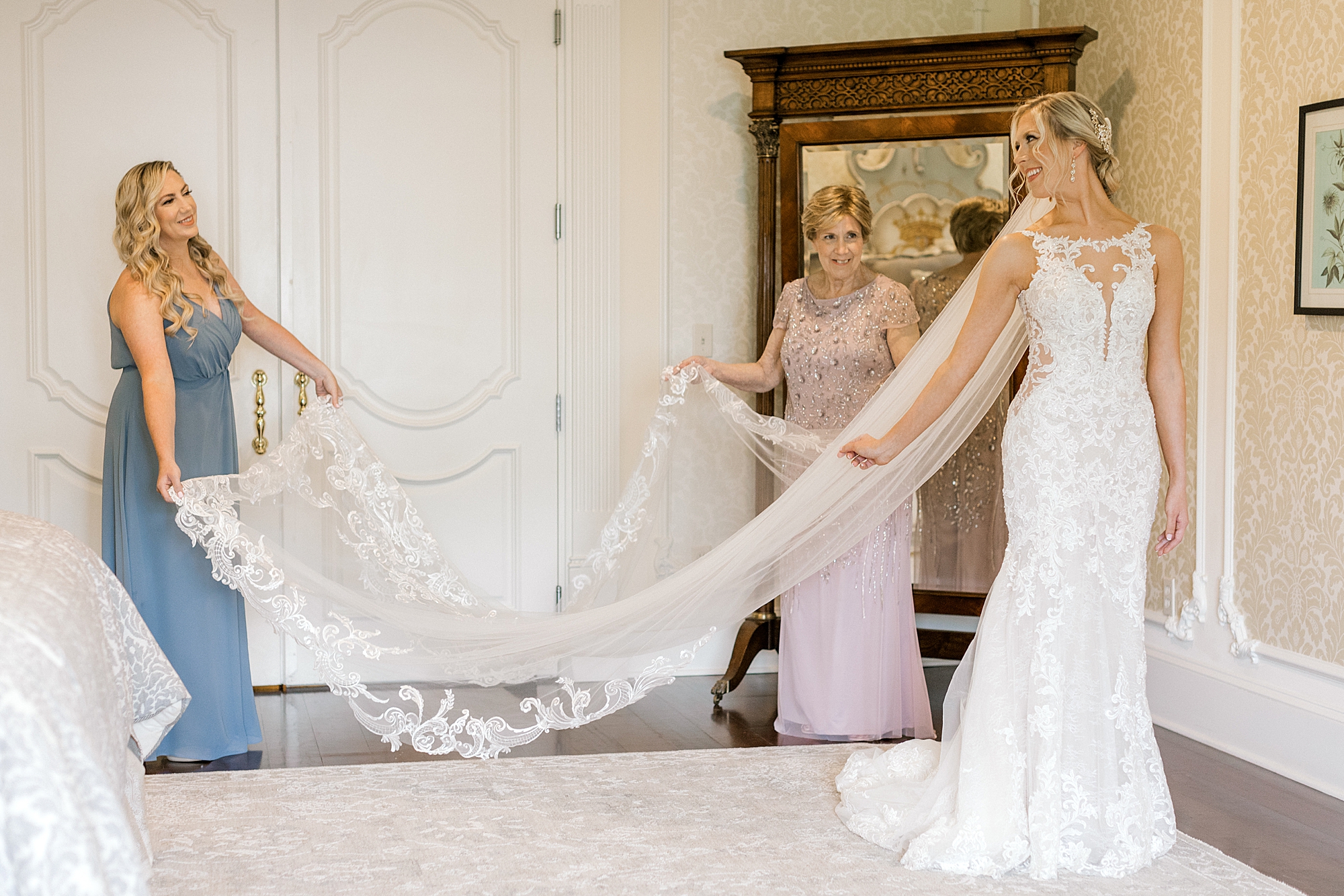 bridesmaid and mother help bride with veil before NJ wedding day
