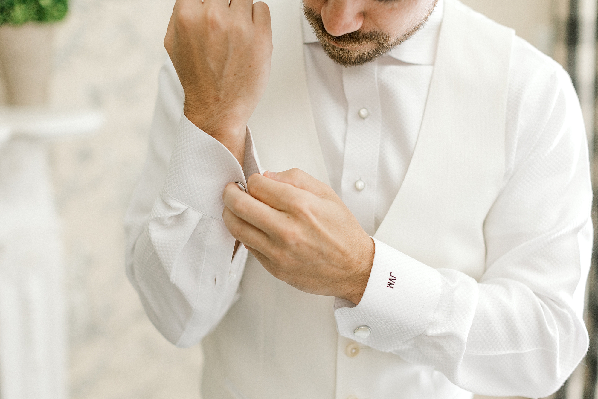 groom adjusts white cufflinks before NJ wedding